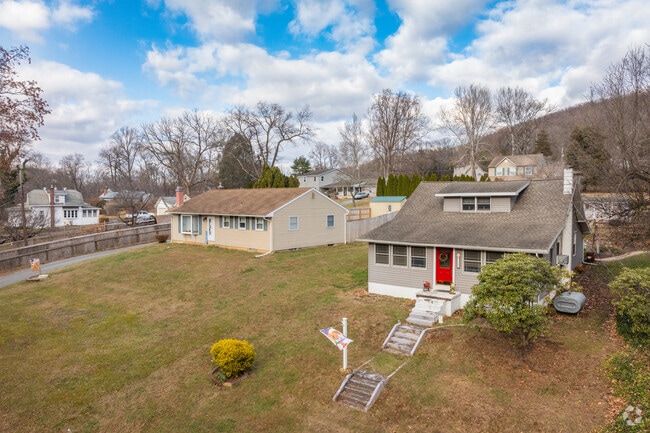 Bungalows and ranch homes with yards sit on slopes in the elevated areas of Earl.