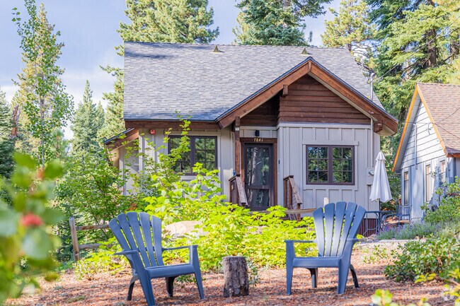 Two chairs are in front of a tiny Tahoe Vista cabin.