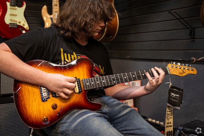 A young shopper browses guitars at Midwest Drum & Percussion in East Front/Sunnyside.