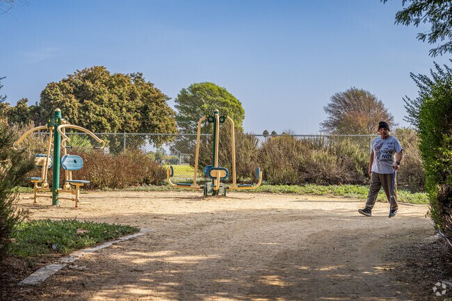 A hiker walking past workout equipment at Orange Grove Park in Hacienda Heights