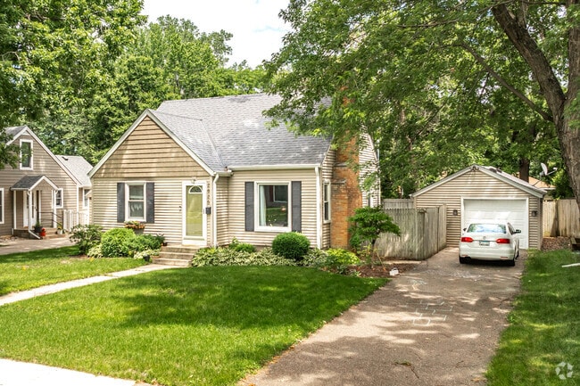 A cozy cottage with a detached garage and spacious driveway.