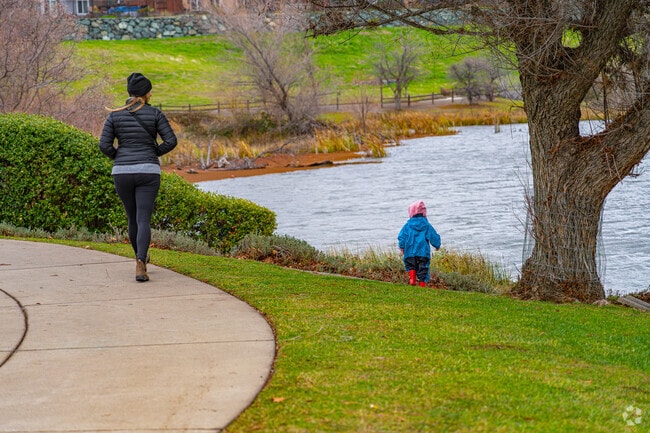 Young boy throws sticks into Coyote Pond Park pond in Twelve Bridges Village.