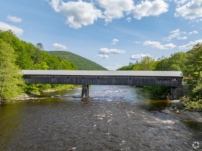 The Dummerston Covered Bridge, Vermont's longest still in use, is a wooden marvel spanning the West River with timeless beauty.