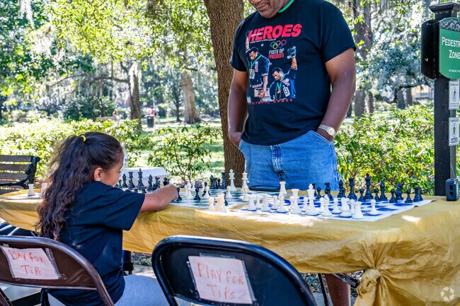 Residents of all ages can enjoy a game of table chess in the park.