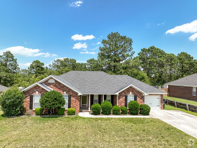 A dormered brick bungalow in Belair with manicured landscape,