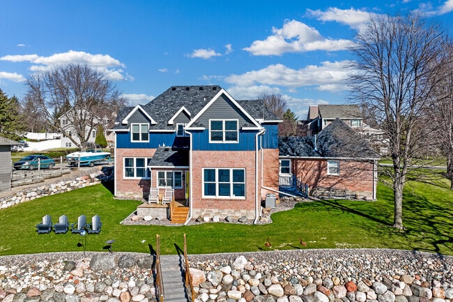 An elegant craftsman-style home with upscale landscaping sits on the shores of Lake Pulaski.