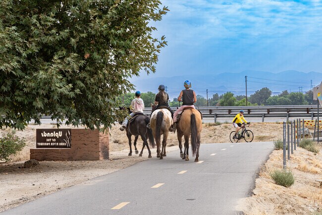 Horseback riders traverse the Kern River Parkway in Homaker Park.