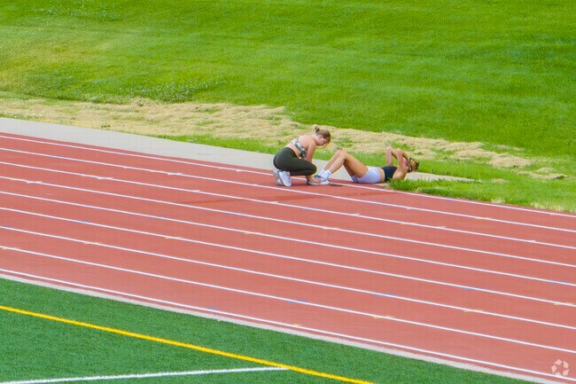 Friends help each other in there summer work out at Niwot High School Track.