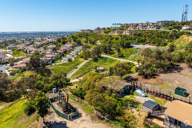 The terraced hillside still has active oil derrick pumps in Signal Hill.