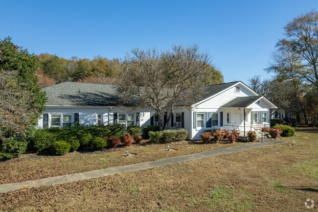 A white single-story home surrounded by bushes with a large front yard in Slater-Marietta.