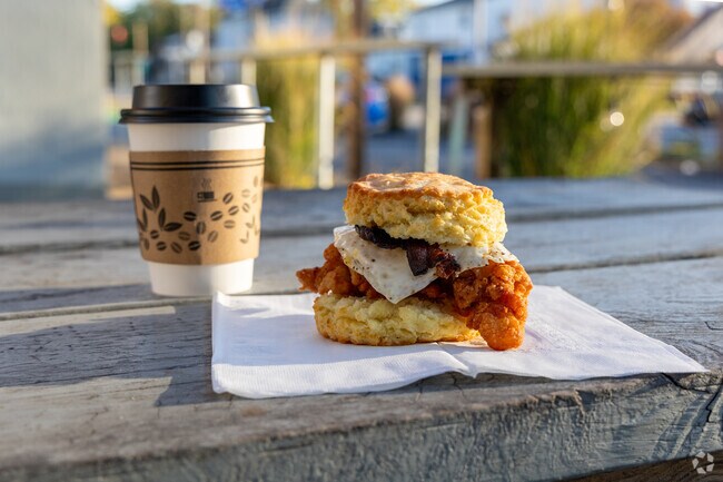 Residents enjoy a fried chicken and biscuit sandwich on the patio at Handsome Biscuit near Barraud Park.
