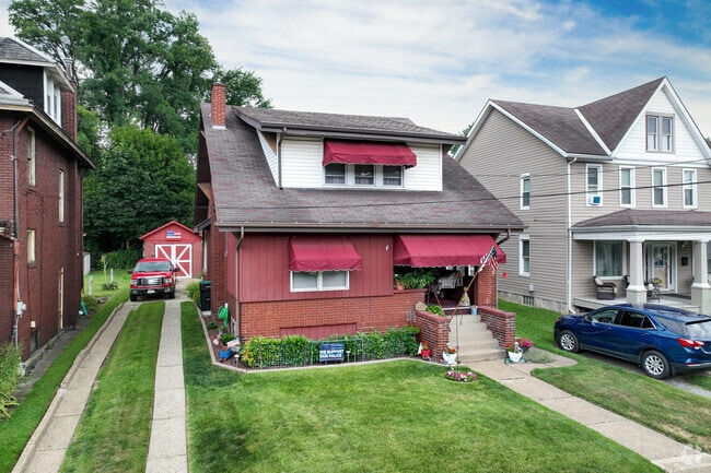 A red bungalow house with a front yard perfect for your furry friend, in Tarentum.