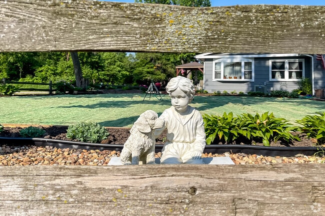 A small statue of a boy with his dog stands in a Jewell Road resident's front yard.