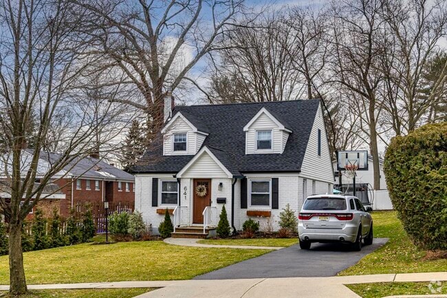 A colonial style home sits off of a main street in Oradell NJ.