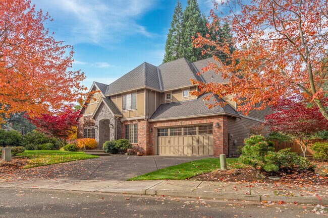 A large custom traditional home is hugged by fall foliage in Marylhurst.