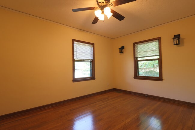 Large bedroom with sconces and ceiling fan