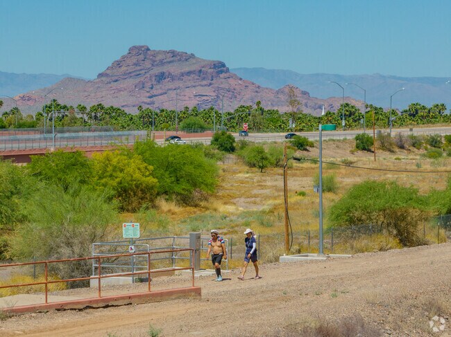 Hikers enjoy a hike through Sun Circle Trail with Red Mountain in the backdrop.