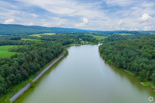 The aerial view shows Sweet Arrow Lake surrounded by lush greenery.