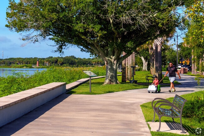 A father pushes his son in a motorized car, enjoying nature and laughter in Mill Slough.