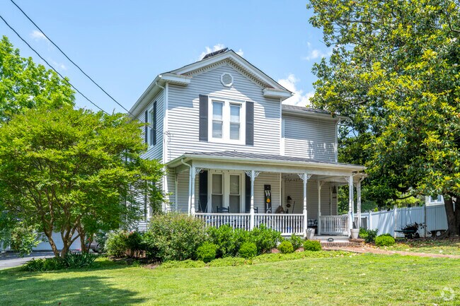 A classic farm house with a spacious yard and porch.
