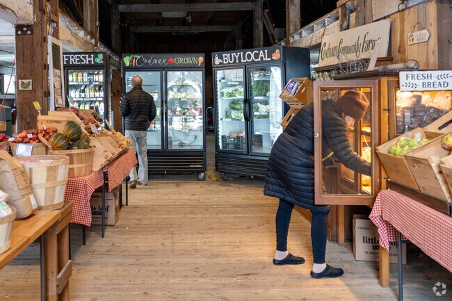 Folks browse shelves at the self serve farm stand at Codman Community Farms in Lincoln.