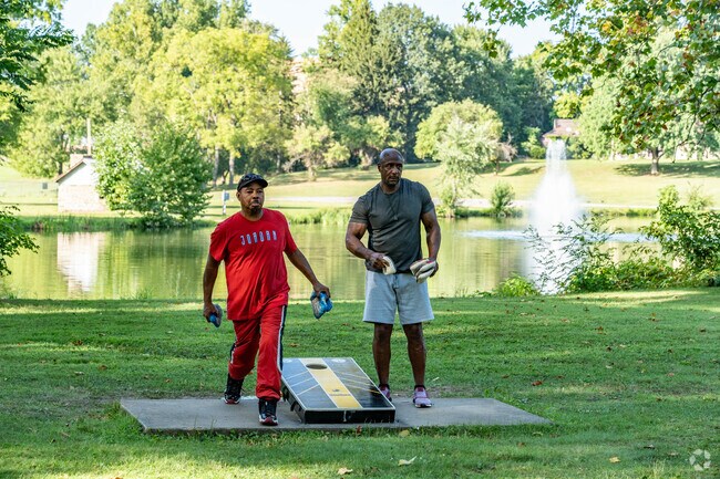 Friends enjoy a game of corn hole in Packard Park in Warren.