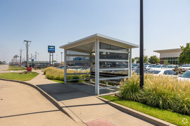 A shaded bus stop offers comfort and respite from the sun in the heart of Prattville.