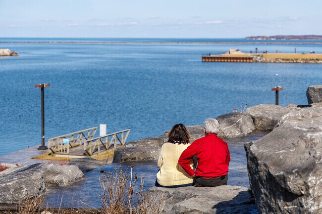 A couple sit and take in the views of Lake Ontario at Breitbeck Park.