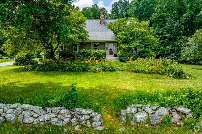 Home set back from the road behind a rock wall and nice landscaping in Greater Southborough.