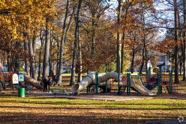 Adults and children enjoying a break at the playground in Unami Park, Cranford, NJ.