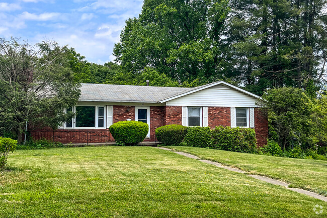 Well-maintained ranch and split-level homes stretch over rolling hillsides enclosed by towering old oaks. 03