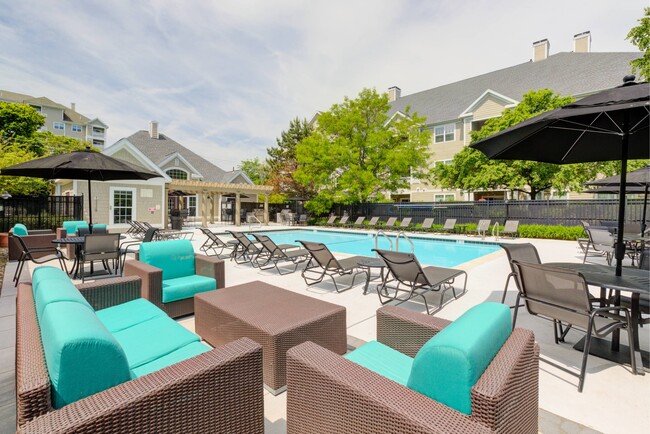 View of pool with soft seating, loungers, tables and umbrellas