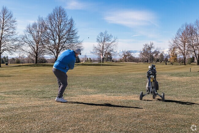 A Kaysille man plays golf at Davis Park Golf Course under a blue sky.