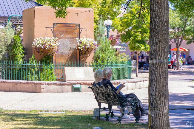 A couple reads and enjoys the day at Santa Fe Plaza in Glorieta.