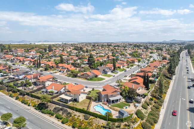Red tile-roofed single-family homes dot the landscape of Orangecrest, as seen from above.