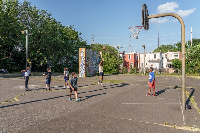 A group of young teenagers play a game of pickup basketball at Liney Ditch Park.