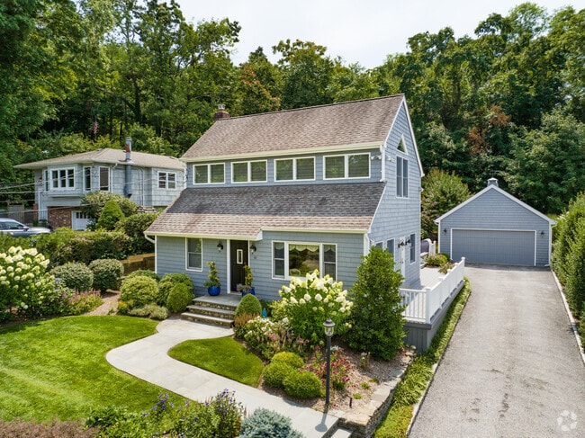 Dutch Colonial style adds timeless charm to this spacious Laurel Hollow residence.
