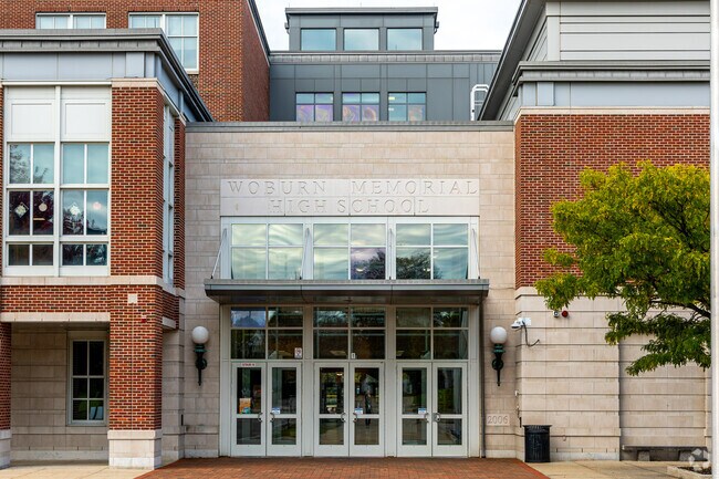 The Woburn High School building features a contemporary design with many glass windows.