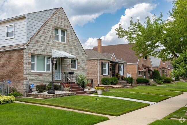 Row of Cape Cod homes with manicured green lawns and tree lined streets, East Side, Chicago.