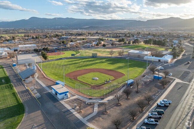 Camp Verde High School students huddle after a game of baseball in the evening.