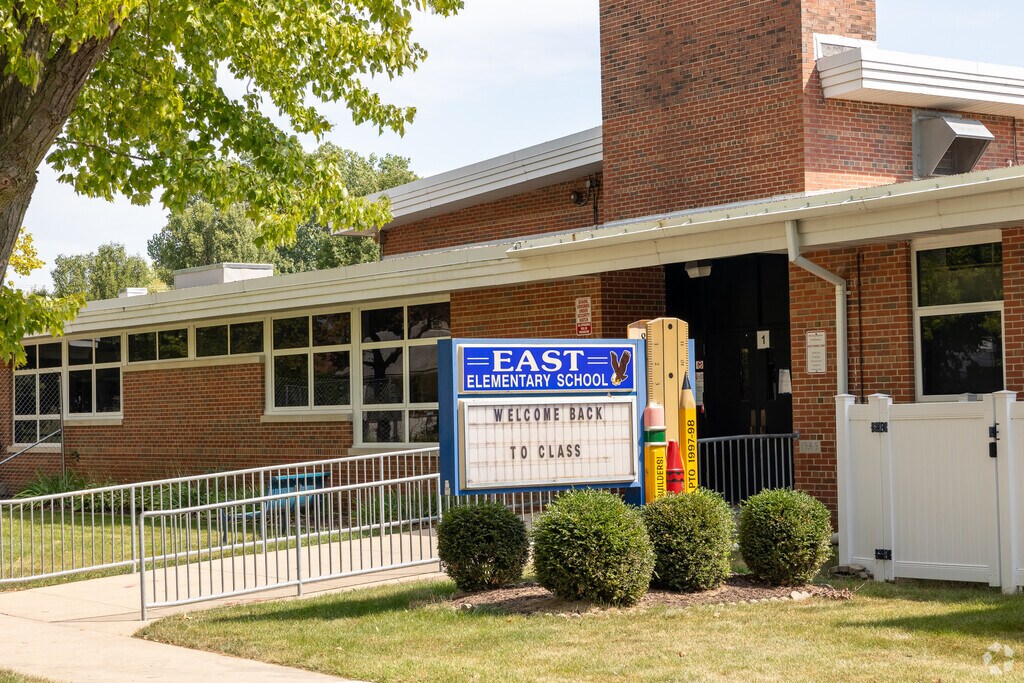 The front entrance to East Elementary School in Zion, IL. featuring a unique school supply sign.