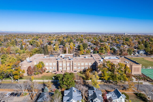 Skinner Middle School has a backdrop of trees and residential houses.