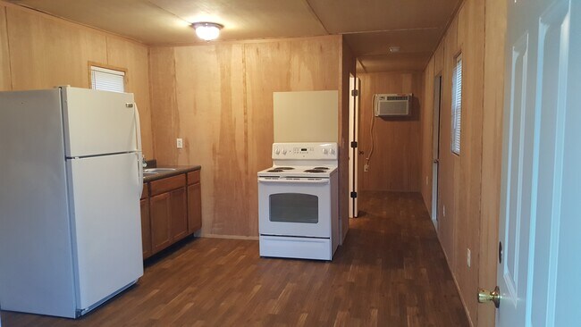 Full kitchen, hallway leading to bed and bath.