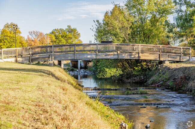 A wooden pedestrian bridge crosses over Joplin Creek as it flows along Campbell Parkway.
