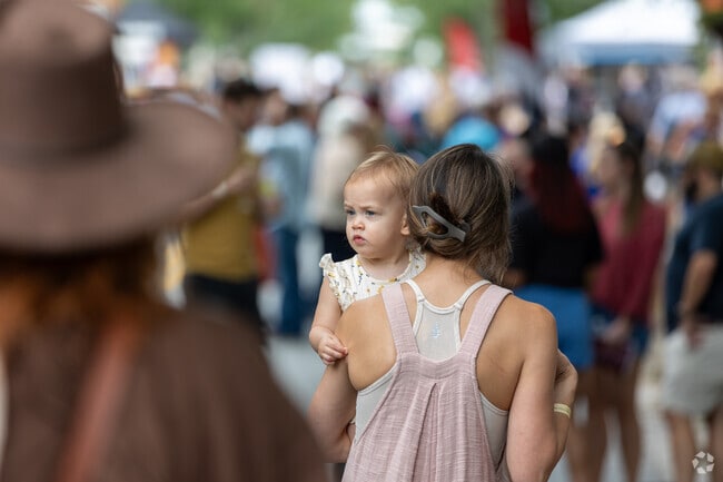 A little girl held by her mother at the Roswell Wine Festival