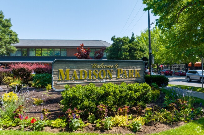 A beautiful wooden sign welcomes residents and visitors to Madison Park.