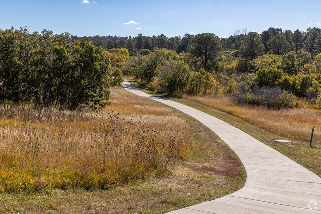 Woodlands Bowl Trail has a natural landscape with a paved walking path.