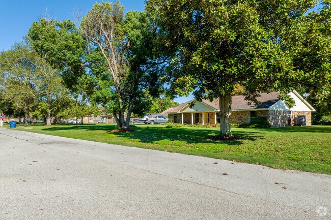 Homes in Jones Creek sit underneath mature oak trees.