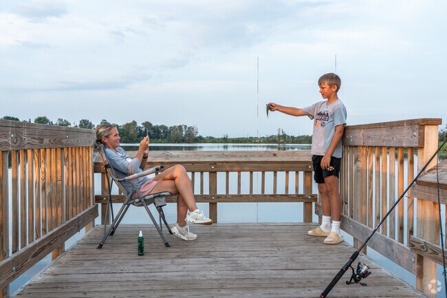 A boy holds up his catch while fishing from a pier at Indian Point Campground in Irving.