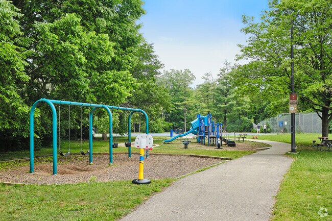 Woodbury Park has a winding path that leads past a swing set and full playground.